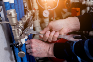 Engineer tightening a bolt on the pipes of a underfloor heating system